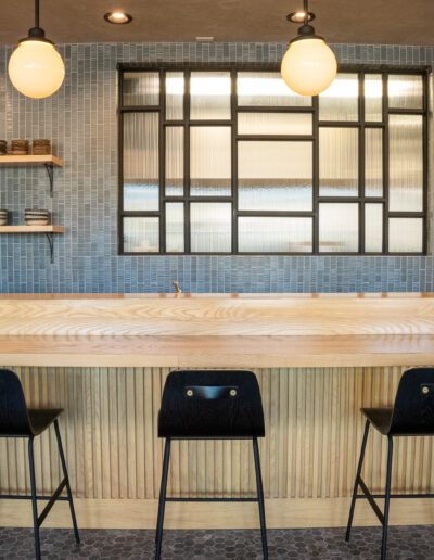 A bar with black stools in front of it.