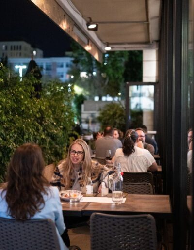 A group of people sitting at tables outside at night.