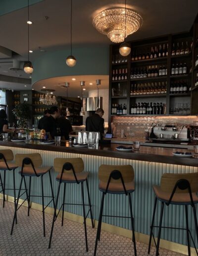 The bar area of a restaurant with many stools.