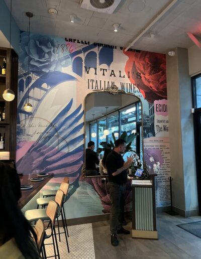 The interior of a restaurant with a mural on the wall.